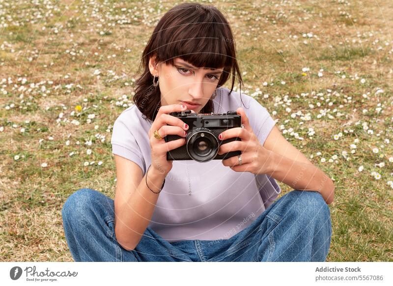 Frau fotografiert mit Retro-Kamera im Stadtpark fotografieren Fotoapparat altehrwürdig Tourist Fotografie Natur jung brünett lässig retro Filmmaterial Park