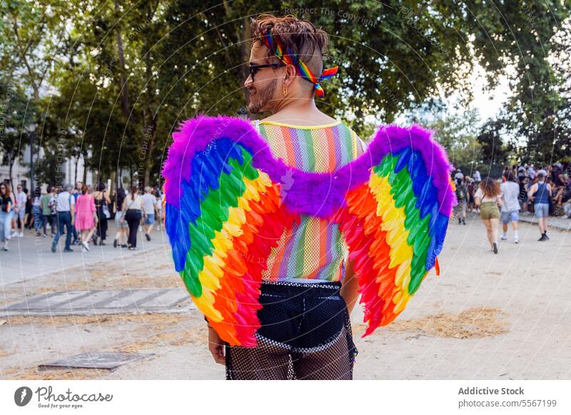 Stolzes Display im Park Mann Regenbogen Flügel Accessoire lgbtq Menge Feier pulsierend Farbe Stadtfest Ausdruck Einheit Freiheit Symbol im Freien Vielfalt