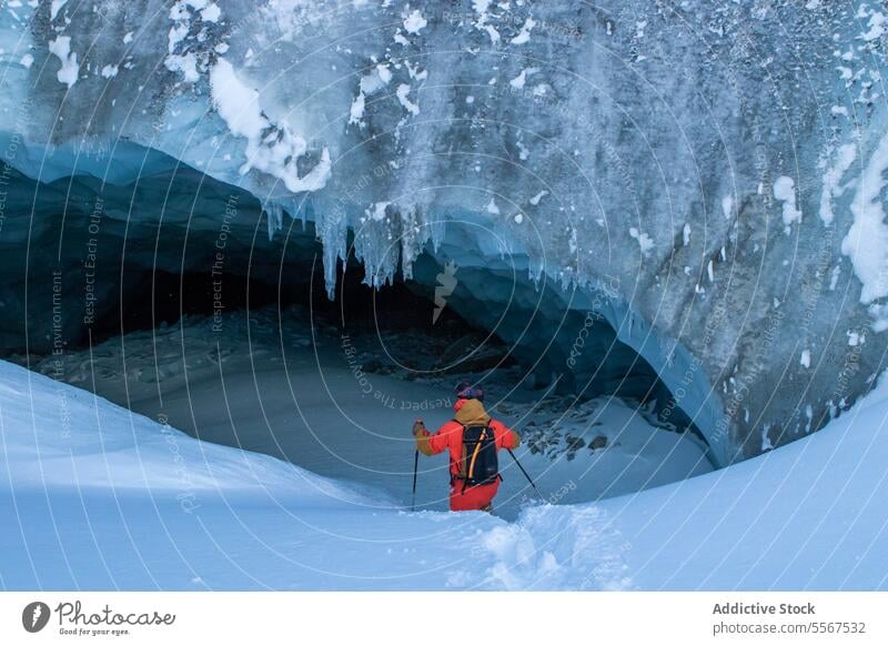 Skifahrer mit Skistöcken erkundet Höhle auf Schneeberg unkenntlich Mast laufen verschneite Berge u. Gebirge erkundend Urlaub Erkundung Person wandern Winter