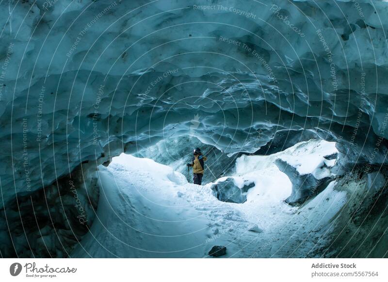 Skifahrer mit Skistöcken erkundet Höhle auf Schneeberg unkenntlich Mast laufen verschneite Berge u. Gebirge erkundend Urlaub Erkundung Person wandern Winter