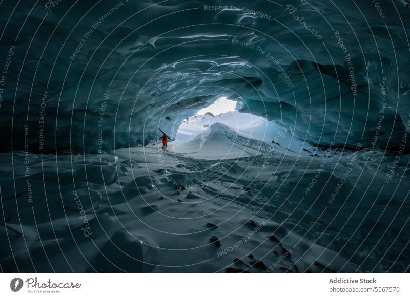 Skifahrer mit Skistöcken erkundet Höhle auf Schneeberg unkenntlich Mast laufen verschneite Berge u. Gebirge erkundend Urlaub Erkundung Person wandern Winter