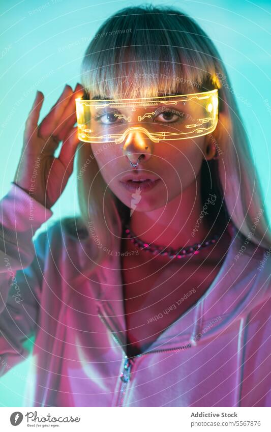 Frau mit futuristischer VR-Brille jung Leuchtdiode Virtuelle Realität selbstbewusst Porträt Schutzbrille Stil modern Licht leuchten cool Headset Simulator