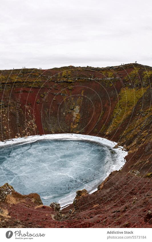 Wunderschöner Krater mit gefrorenem See inmitten brauner Bergkuppen Hügel vulkanisch Natur Schnee Berge u. Gebirge malerisch weiß Winter kalt Eis Windstille