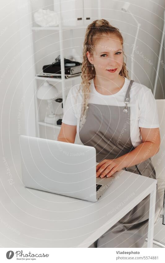 Frau Professionelle Maniküre an ihrem Schreibtisch arbeitet mit einem Laptop. Registrieren Sie sich für Maniküre Dienstleistungen, Freelancer Work Schedule