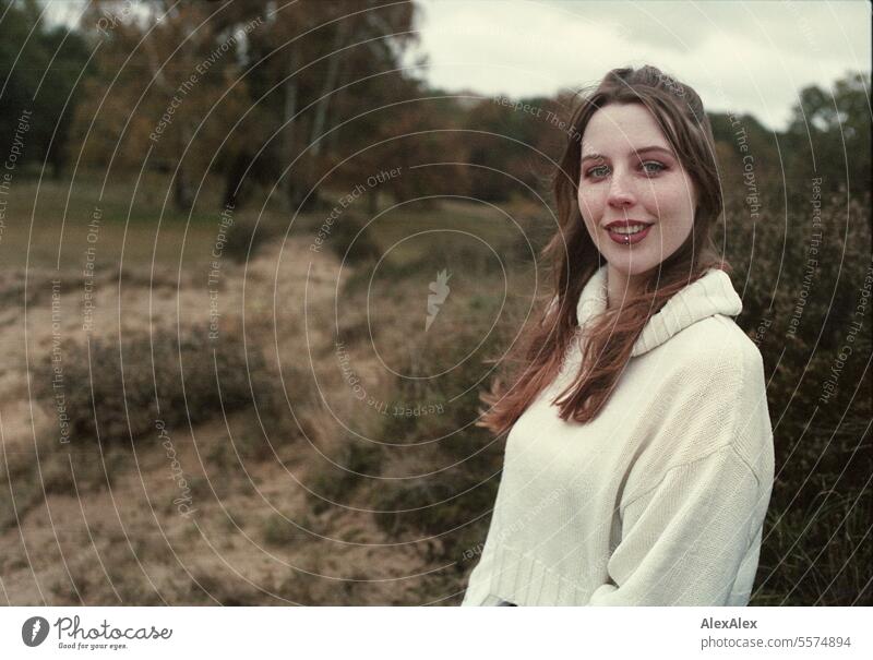 Junge Frau in weißem Wollpullover in einer Heidelandschaft im Herbst - analoges Kleinbild junge Frau groß große Frau schlank hell Freude Landschaft