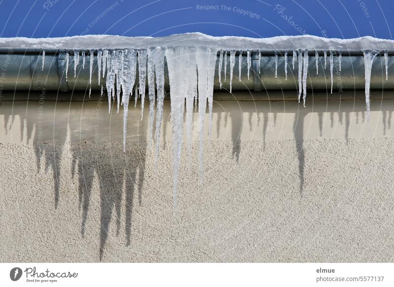 Eiszapfen mit Schatten an der Dachrinne eines Gebäudes Winter kalt gefroren Frost Schnee Wasser Kälte Blog Winterstimmung frostig Klima Wetter Minusgrade