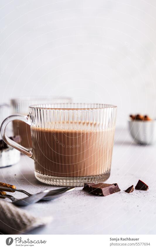 Ein Glas heiße Schokolade auf einem grauen Tisch. Nahaufnahme. Kakao Heißgetränk Trinkglas Lebensmittel lecker Foodfotografie süß Innenaufnahme braun Milch