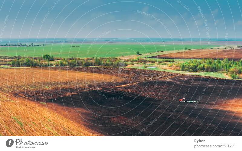 Luftaufnahme Erhöhte Ansicht. Roter Traktor pflügt Feld. Beginn der Park im Freien Saison Land Zähne Maschine Ackerland pflügen Natur gezogen Gerät kultiviert