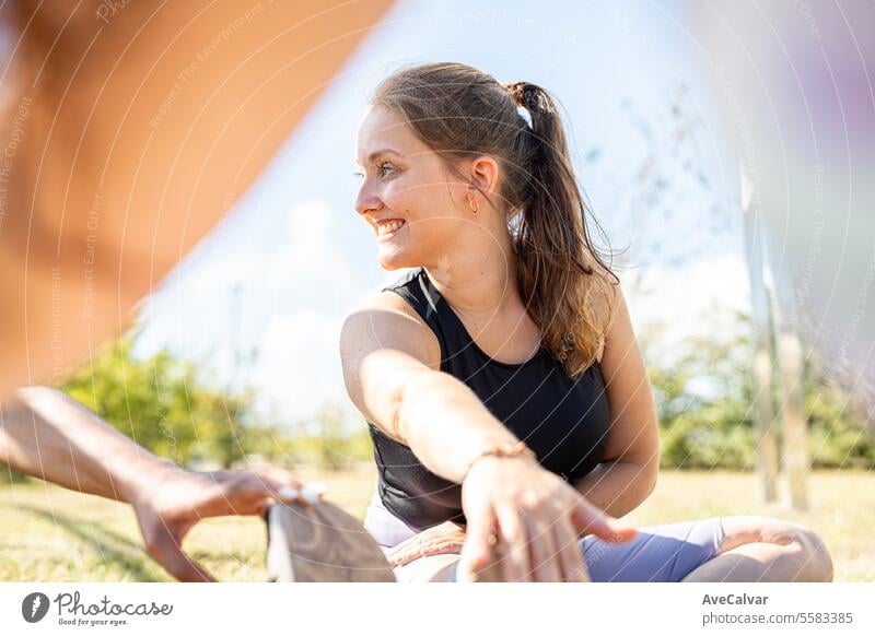 College-Mädchen, die sich nach einem harten Workout in Sportkleidung auf dem Boden sitzend dehnen. Universitätscampus. Person jung Lifestyle Frau Erwachsener