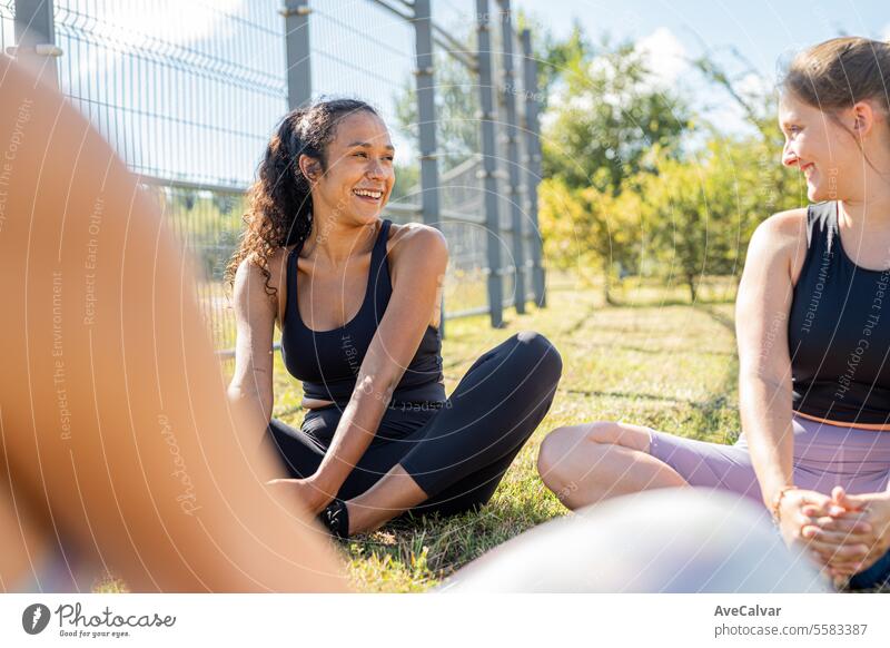 College-Mädchen, die sich nach einem harten Workout in Sportkleidung auf dem Boden sitzend dehnen. Universitätscampus. Person Fitness Frau Lifestyle trainiert.