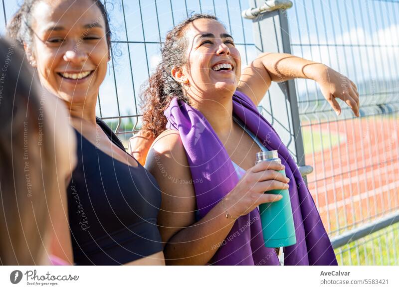 Eine Gruppe von Freunden unterhält sich und bereitet sich mit Wasser und Handtüchern auf eine schweißtreibende Übung vor. Gesundes Leben. Fitness Person