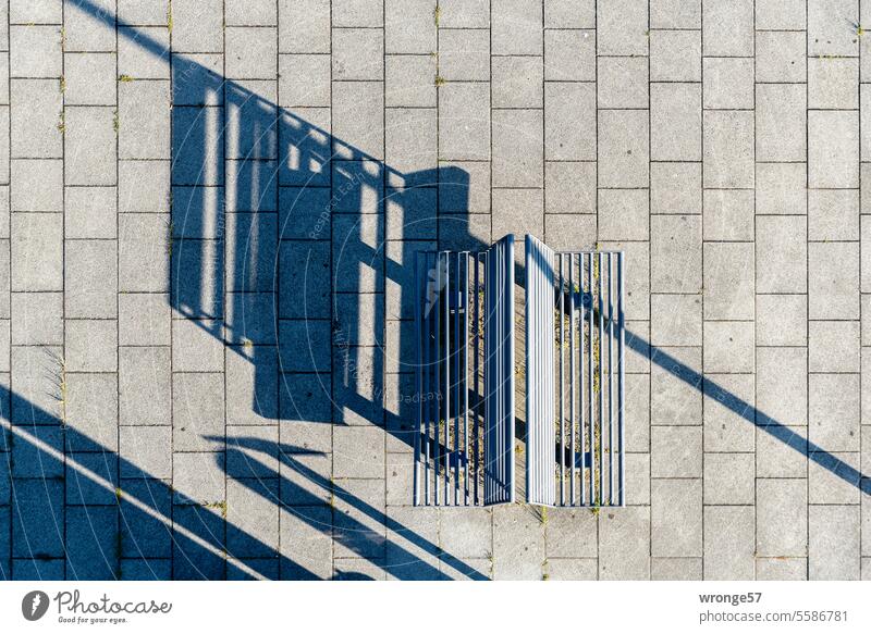 Zwei Sitzbänke mit langen Schatten aus der Vogelperspektive Sitzbank Schattenspiel Schattenwurf lange Schatten Licht und Schatten Sonnenlicht Muster