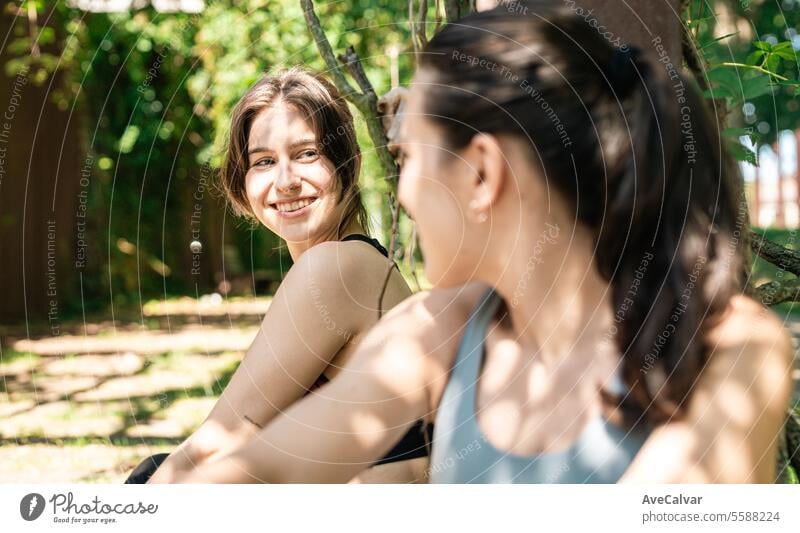 Zwei junge, fitte, fröhliche Mädchen sitzen ausgeruht nach dem Sport und freuen sich, ihre sportlichen Ziele zu erreichen. Lifestyle Frau Glück Frauen Person