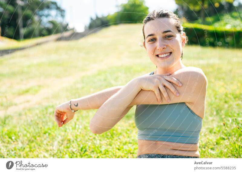 Sporttrainerin, die zeigt, wie man sich dehnt, um Verletzungen außerhalb des Hauses zu vermeiden. Gesunder Lebensstil. Frau jung Sommer Person Lifestyle