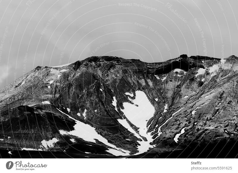 Blick auf felsige Hügel und Berge auf Island Islandreise isländisch Wetter Klima Islandbild Ruhe dunkel geheimnisvoll Bergseite Hügelseite einsam himmelgrau