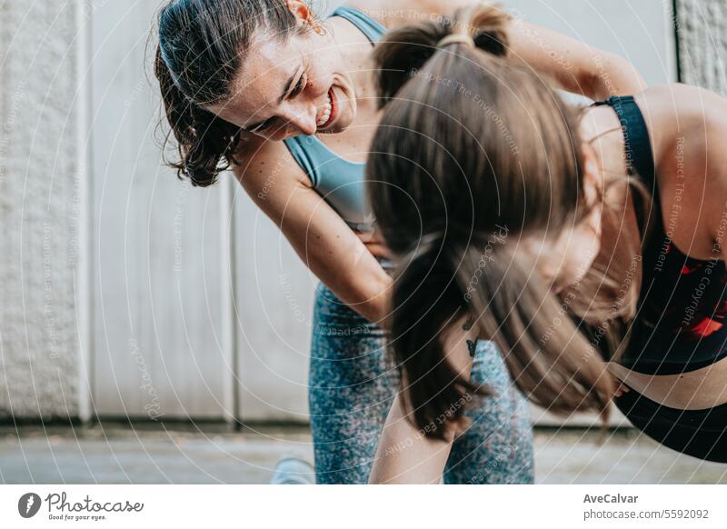 Junge Leute, die außerhalb des Hauses trainieren und sich gegenseitig helfen, Liegestütze zu machen. Gesunder Lebensstil. Sport Person jung im Freien urban