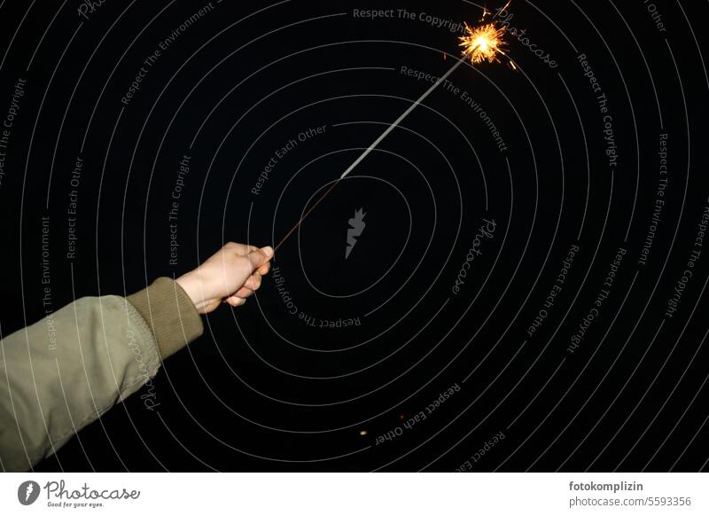 Hand hält eine sprühende Wunderkerze in den schwarzen Himmel Feuerwerkskörper Feste & Feiern Freude explodieren Funken dunkel brennen Nacht glühen leuchten
