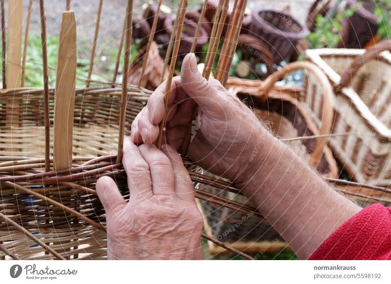 Korbmacher bei der Arbeit korbmacher flechten korbwaren hand weide geflochten zweig handarbeit handwerk kunsthandwerk herstellung alt closeup detail