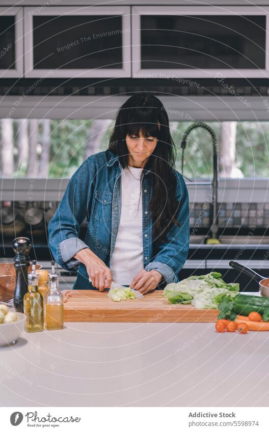 Mittlere erwachsene Frau Hausfrau bereitet frischen Salat vor Vertikale Aufnahme Avocado Schalen & Schüsseln Küchenchef hacken zerkleinernd Essen zubereiten