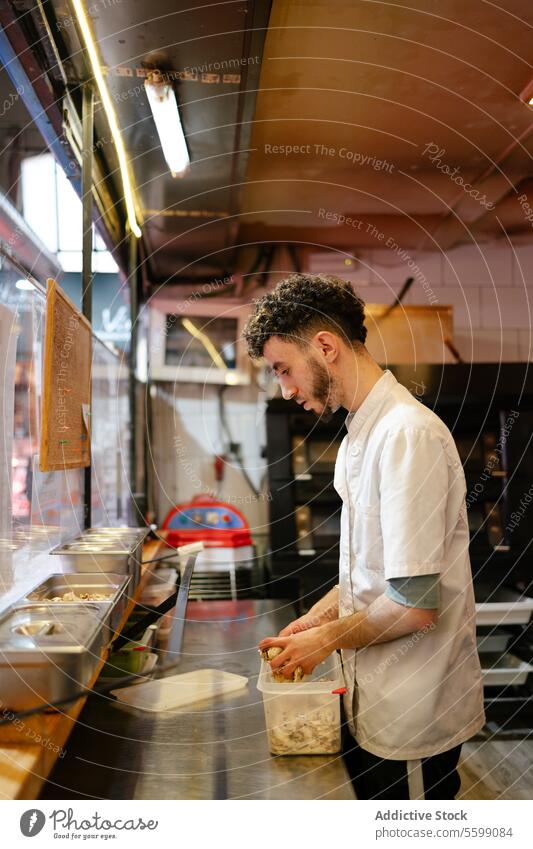 Pizzamann füllt Zutaten in Behälter arabisch Bäcker Pilze Brot Bäckerei Vorbereitung Teigwaren frisch arbeiten Skala Gewichtung Schulterblatt Herstellung Mehl