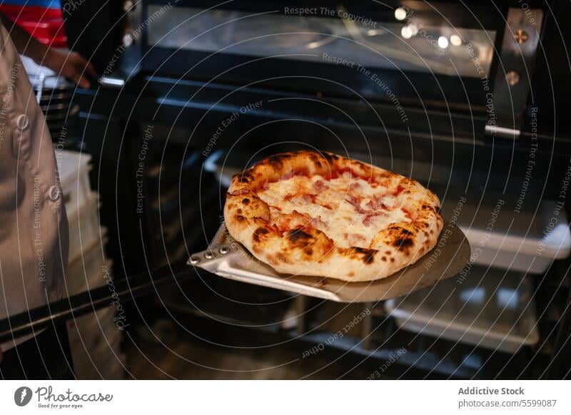 Pizza auf einer Schaufel frisch aus dem Ofen unkenntlich Mann Lebensmittel Italienisch Restaurant schaufeln Abendessen Schinken neapolitanisch Käse traditionell