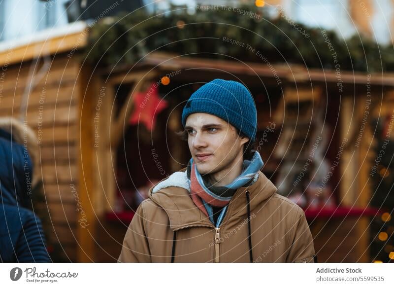 Junger Mann erkundet einen festlichen Weihnachtsmarkt in Quebec, Kanada jung Weihnachten Markt im Freien Beanie Jacke Feiertag Dekoration & Verzierung hölzern