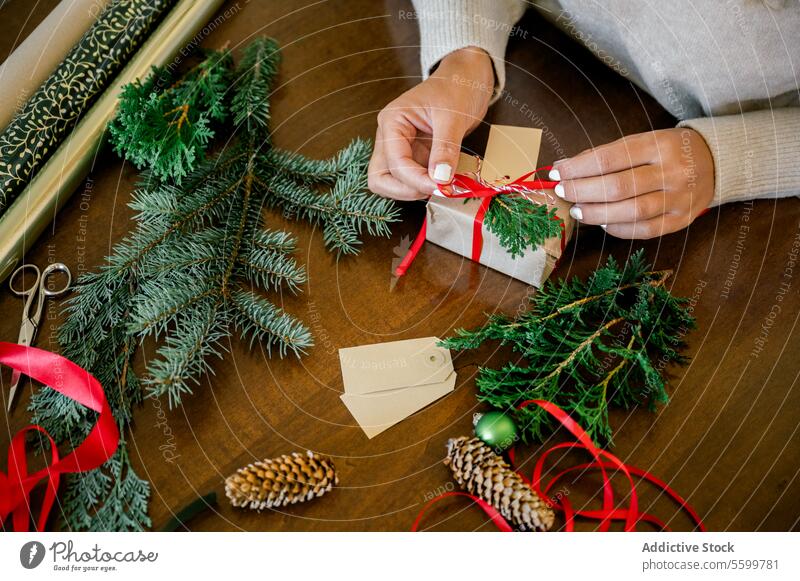 Frau packt schönes Weihnachtsgeschenk am Tisch ein Weihnachten Person Feier präsentieren Verpackung Feiertag Hand Kasten Überraschung rot festlich Bändchen