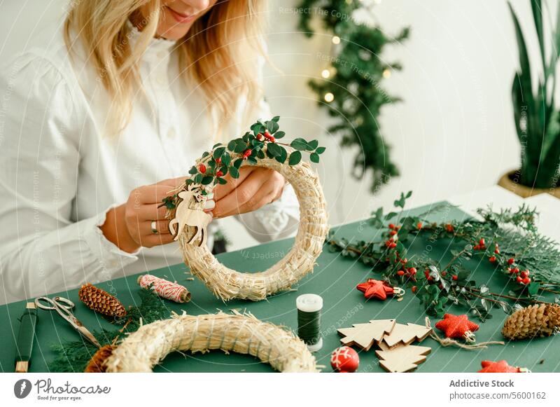 Frau beim Schmücken des Weihnachtskranzes zu Hause Anlass unkenntlich funkeln Zauberei u. Magie Atmosphäre präsentieren Ornament glänzend festlich von oben