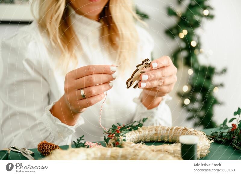 Frau bastelt Weihnachtskranz zu Hause Weihnachten Totenkranz Kugel Dekor Tradition hängen festlich Ast Neujahr Feiertag Inspiration fröhlich Atmosphäre