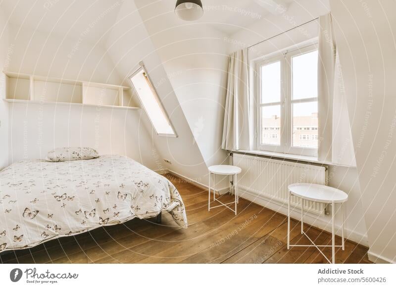 Schlafzimmer mit gemütlichem Bett und Hockern am Fenster Appartement bequem geräumig weiß Wand hell Zeitgenosse Hartholz Stock Kopfkissen Gardine Textfreiraum