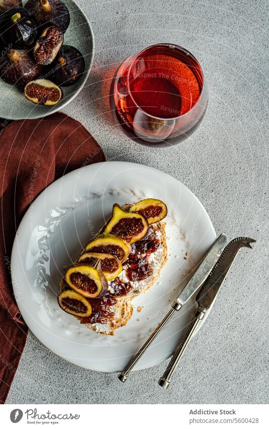 Feige und Toast Delikatesse mit Rotwein Zuprosten Feinschmecker Snack anspruchsvoll weiße Platte Glas speisend kulinarisch Mahlzeit Eleganz Food-Fotografie Stil