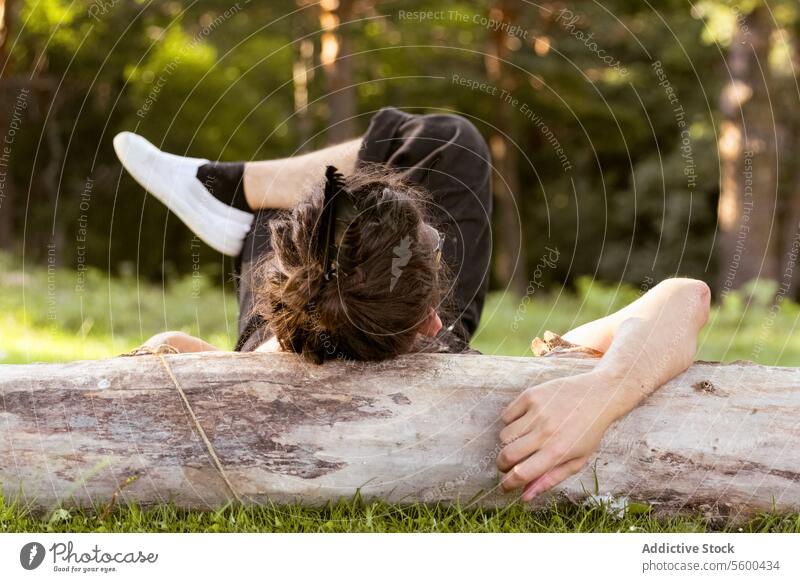 Unbekannte Person, die sich im Wald auf einem Baumstamm ausruht Lügen gefallenes Holz grünes Gras Erholung friedlich Natur im Freien Entdecker Genuss Freizeit