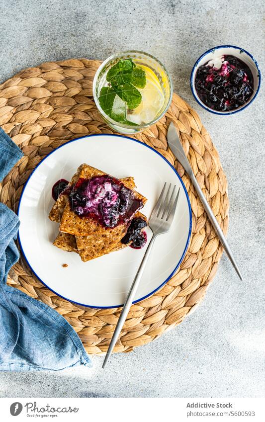 Hausgemachte Crepes mit Blaubeermarmelade und saurer Sahne selbstgemacht Crêpe Blaubeeren Marmelade Sauerrahm Stapel weiße Platte Gabel Belag Klecks Frühstück