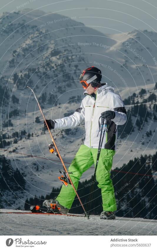 Skifahrer bei der Vorbereitung auf die Abfahrt in den Schweizer Alpen Schnee Berge u. Gebirge Abstieg Berghang Skiausrüstung weiße Jacke grüne Hose Wintersport