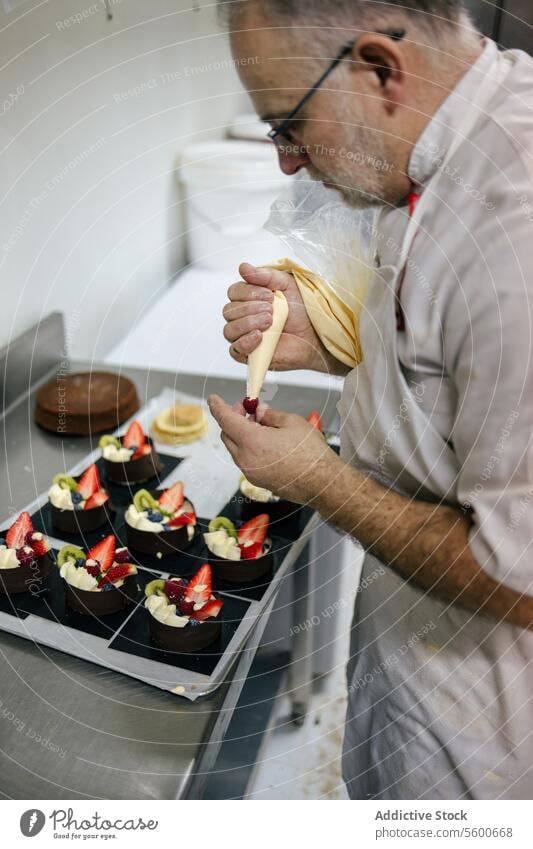 Konditorin mit einem Dressiersack Kuchen Küchenchef Mann Gebäck Tasche Sahne Dessert Dekoration & Verzierung süß Lebensmittel professionell geschmackvoll lecker