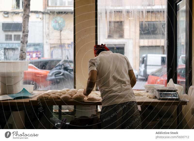 Bäcker bei der Teigbearbeitung arabisch Pizza Küche Lebensmittel Teigwaren Zutaten Focaccia Essen zubereiten jung Mehl Koch Person Rezept Tisch vorbereiten