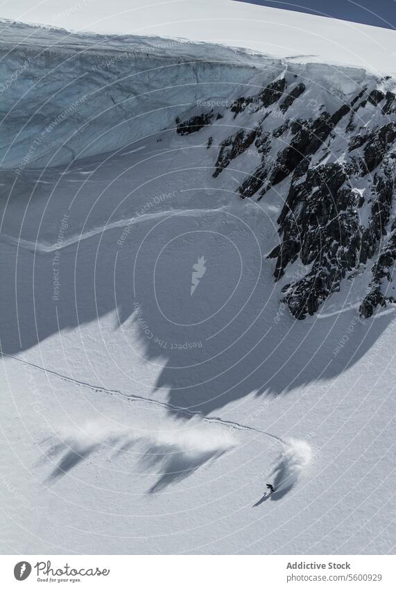 Hohe Winkel der unerkennbaren Person Skifahren auf Schnee Berg während des Urlaubs in den Schweizer Alpen während des sonnigen Tages Skifahrer Berge u. Gebirge