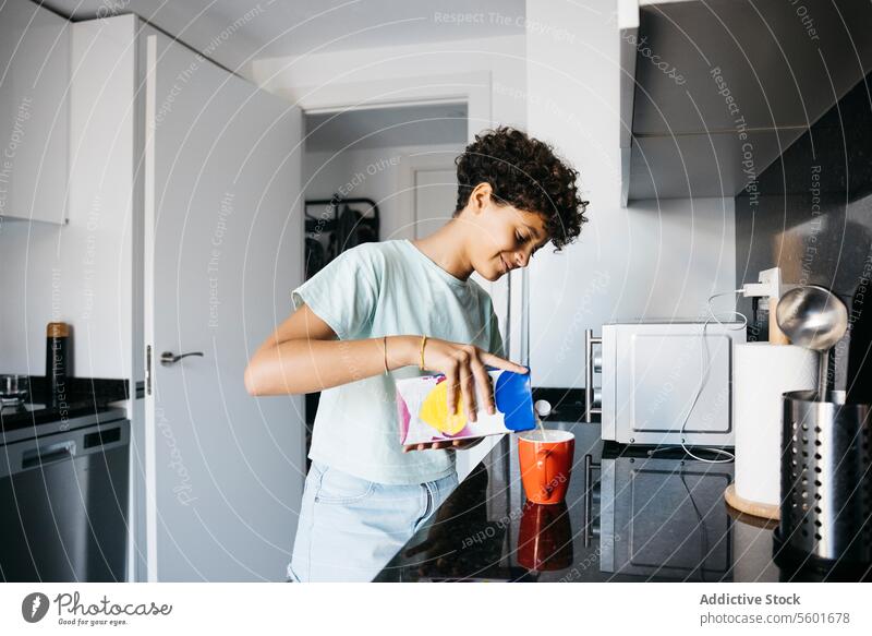 Mädchen bei der Zubereitung einer Tasse Milch Familie Preteen Tochter bezaubernd nach der Schule heiter Kind Kindheit Kinder trinken tägliche Routine