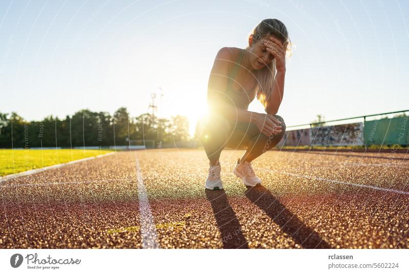 Gestresste Sportlerin, die sich auf einer Laufbahn ausruht aktiver Lebensstil Not leidende Sportlerin Läuferin aussruhen Trainingsmüdigkeit Übung Fitness