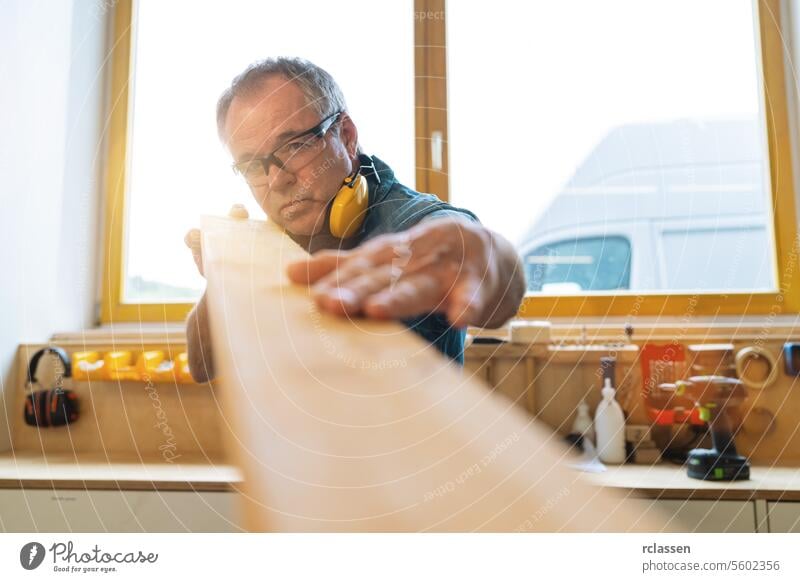 Fleißiger Zimmermann überprüft seine Holzarbeit auf Fehler. Reparatur und Job-Konzept Bild Kunstgewerbler Business Mann Holzbrettchen Hand Konstruktion