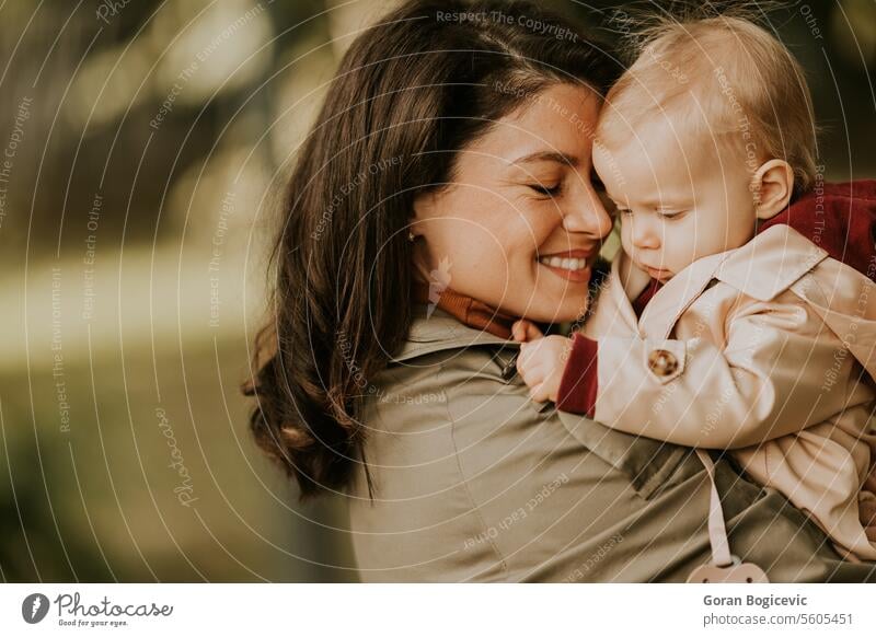 Junge Frau hält süßes Baby Mädchen im Herbst Park klein Kaukasier Mutter außerhalb Tochter Kind wenig Liebe niedlich Beteiligung Fröhlichkeit Zusammensein