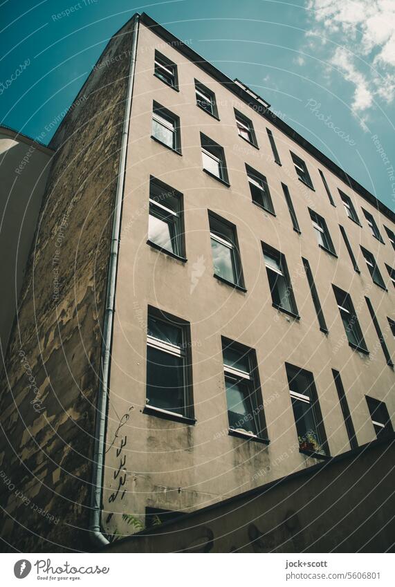 Hinterhaus unsaniert und trist Hinterhof Brandmauer grau Architektur Fenster gewöhnlich authentisch Gedeckte Farben verwittert Fassade Himmel wolkig Sonnenlicht