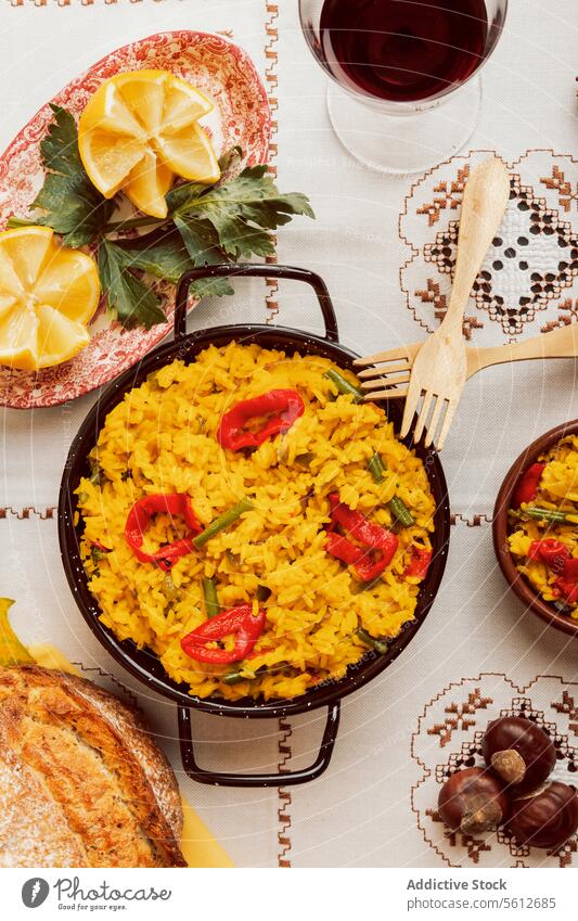 Authentische spanische Paella, serviert mit Brot und Wein spanische Küche traditionell Reis Meeresfrüchte Pfanne Ansicht von oben Tischwäsche Muster Mahlzeit