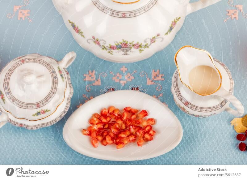 Elegantes Porzellan-Teeset mit Goji-Beeren auf einer Untertasse Kulisse Teller altehrwürdig Tasse Teekanne Pastell blau Hintergrund Geschirr Eleganz