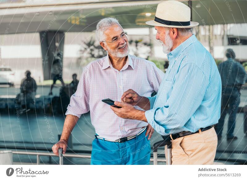 Ages Freunde mit Handy und Koffer am Flughafen Passagier Mobile Telefon Flugplatz Vollbart Freizeitkleidung Fenster modern Nachricht Internet Reisender