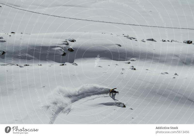 Anonymes Snowboard bei der Abfahrt von einem verschneiten Berg Schnee Berge u. Gebirge Sportbekleidung wolkig Himmel Urlaub Winter sonnig Ganzkörper unkenntlich