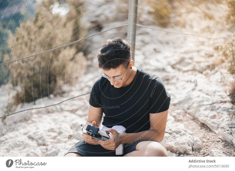 Männlicher Reisender hält Drohnen-Controller auf einem Berg Tourist Smartphone Fernbedienung Dröhnen Fokus Mann Berge u. Gebirge Flucht Technik & Technologie