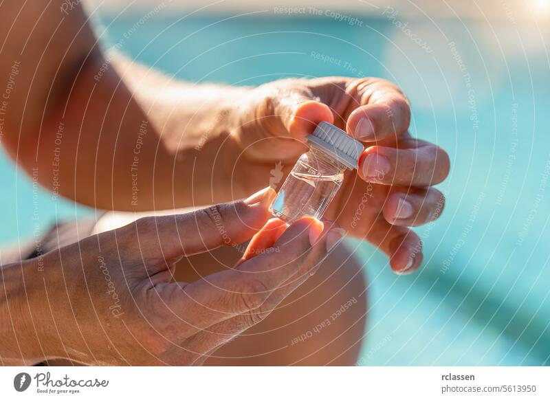 Nahaufnahme Techniker Hände halten ein Fläschchen mit Wasser für pH-Tests in der Nähe eines Schwimmbads in einem Hotel Tintenflüssigkeit gelbe Flüssigkeit Wert