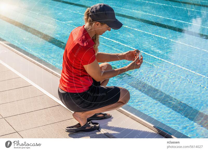 Techniker hockt an einem Pool und untersucht eine Wasserprobe in einem kleinen Fläschchen für einen pH-Test Tintenflüssigkeit gelbe Flüssigkeit Wert Chlor