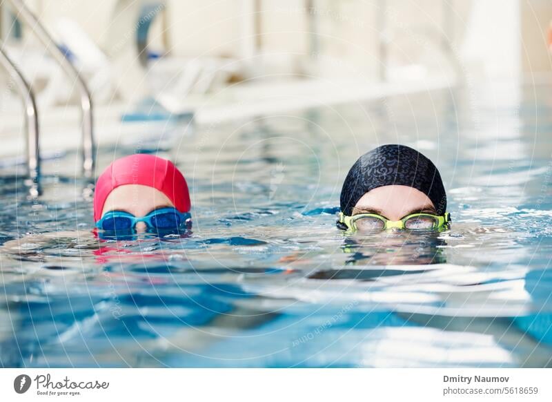 Geschwister verbringen Zeit miteinander im Hallenbad Aktivität aqua Aquapark blau Junge Bruder offen Kind Kindheit Kinder Konkurrenz Sinkflug Genuss Übung